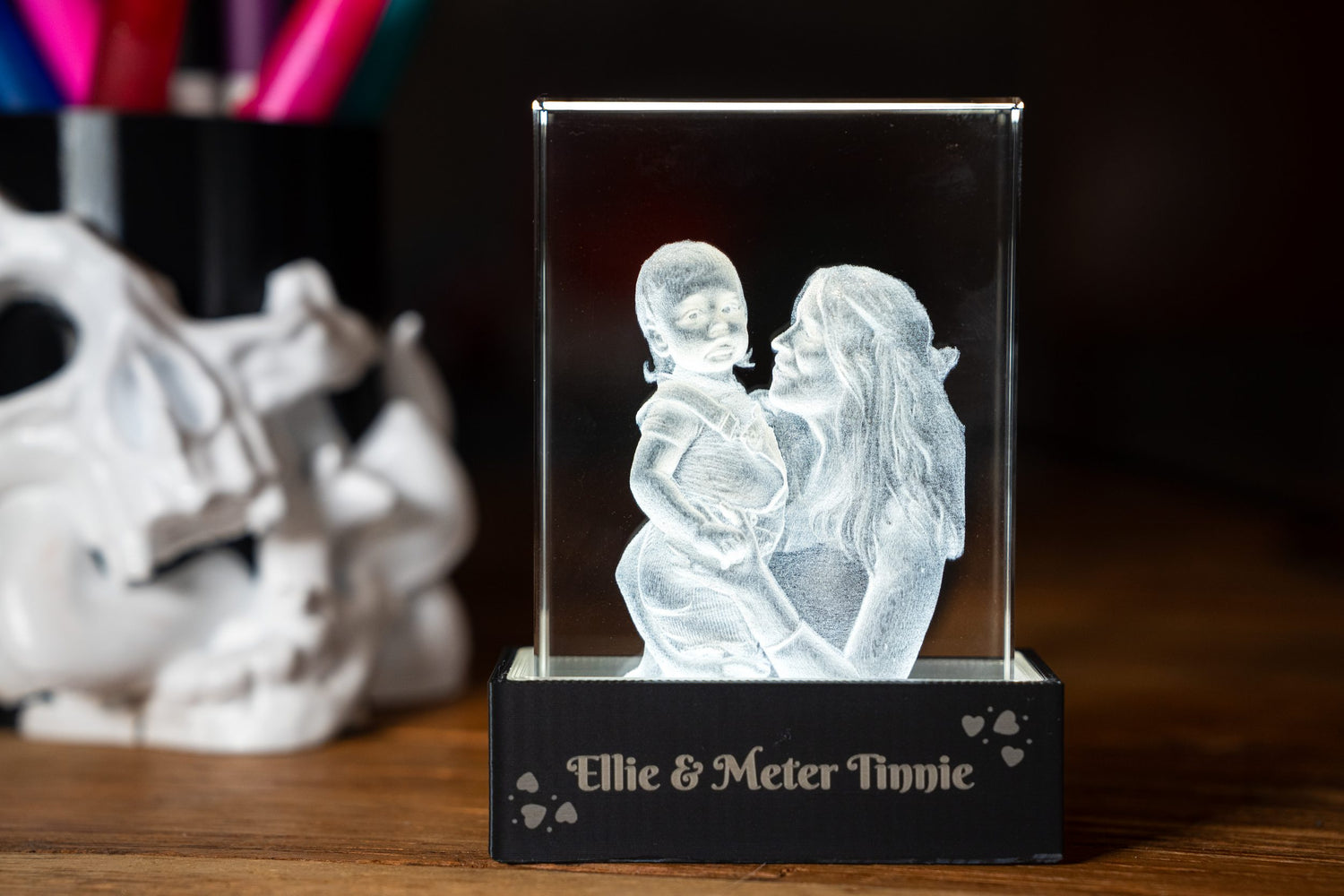 Vitra K9 crystal with inner laser engraving of a mother and child, glowing on its illuminated LED base